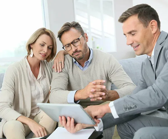 Property agent discussing real estate options with a couple on a tablet, offering personalized guidance.