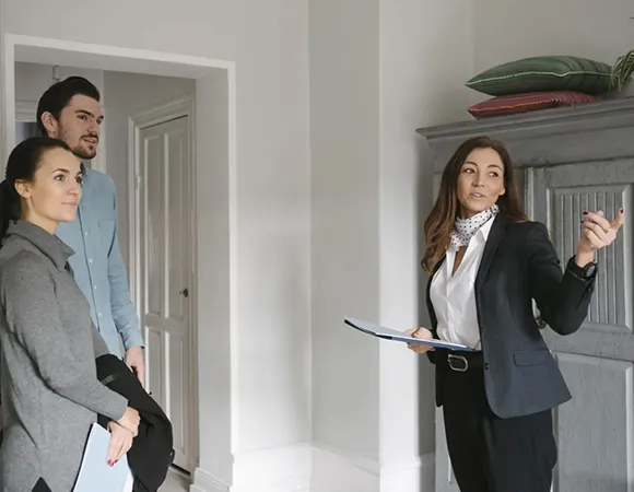 Property agent showing a home to a couple, guiding them through the home-buying process.