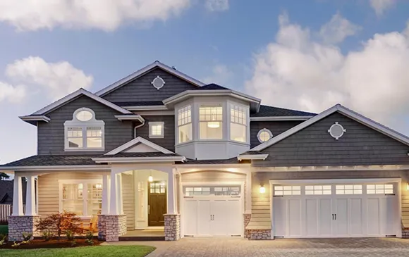 Evening view of a modern home with warm lighting, showcasing its sleek design and inviting atmosphere.